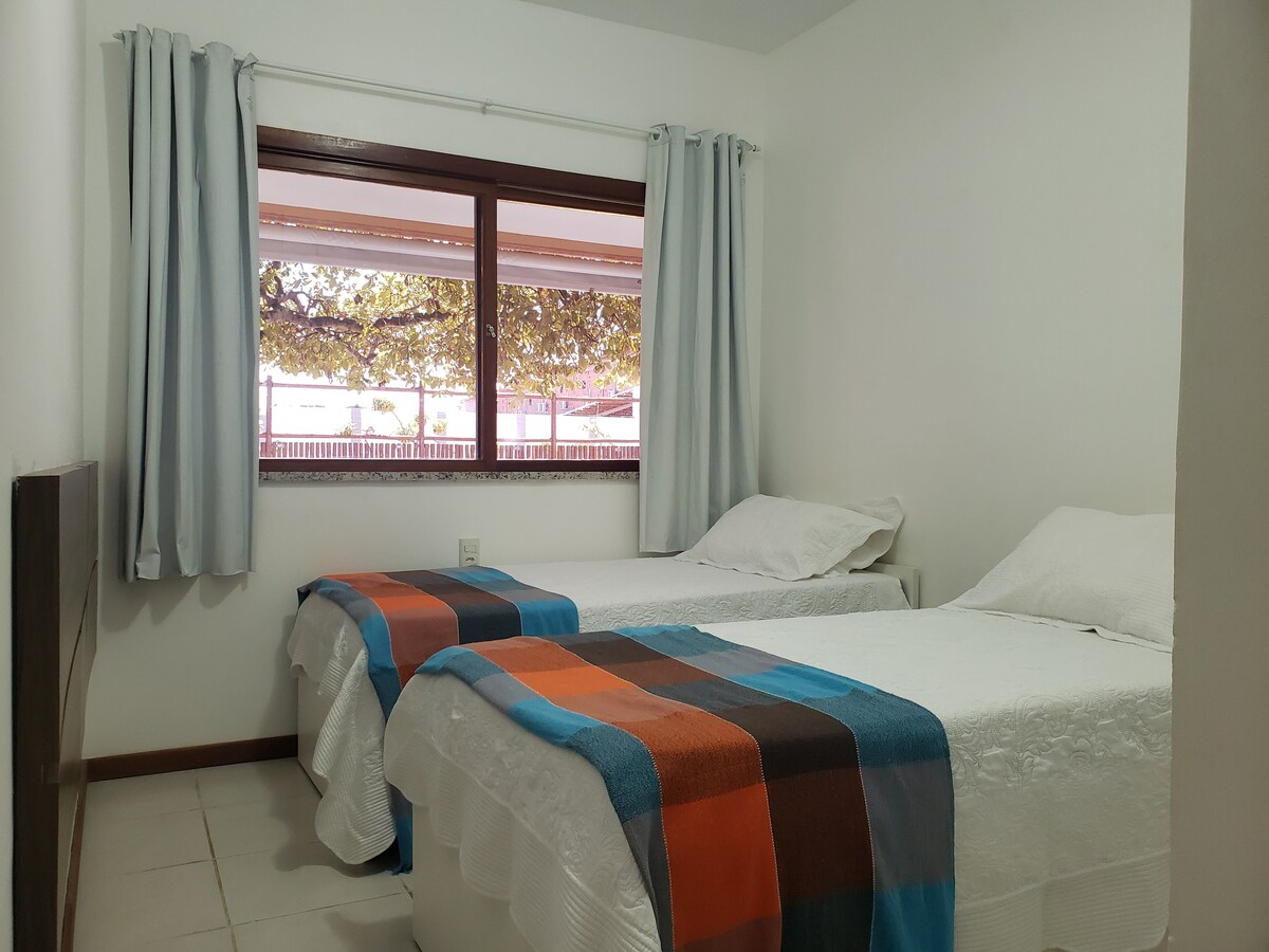 חדר שינה שני עם נוף למרפסת. שתי מיטות, עם מיטות עזר, ארון ופיצול. 