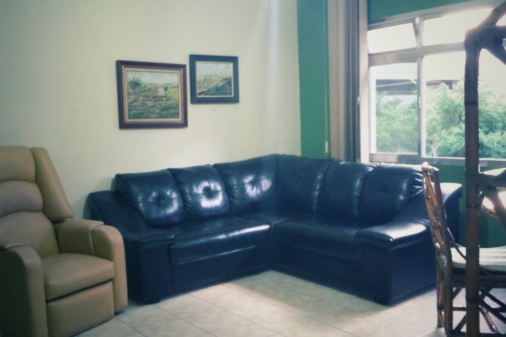 Sala Com 2 sofás, 1 poltrona mesa de jantar e televisão a cabo