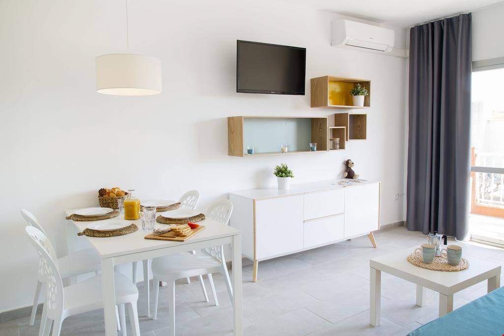 The beautiful living area features a dining table, a flat-screen TV and a comfy sofa.