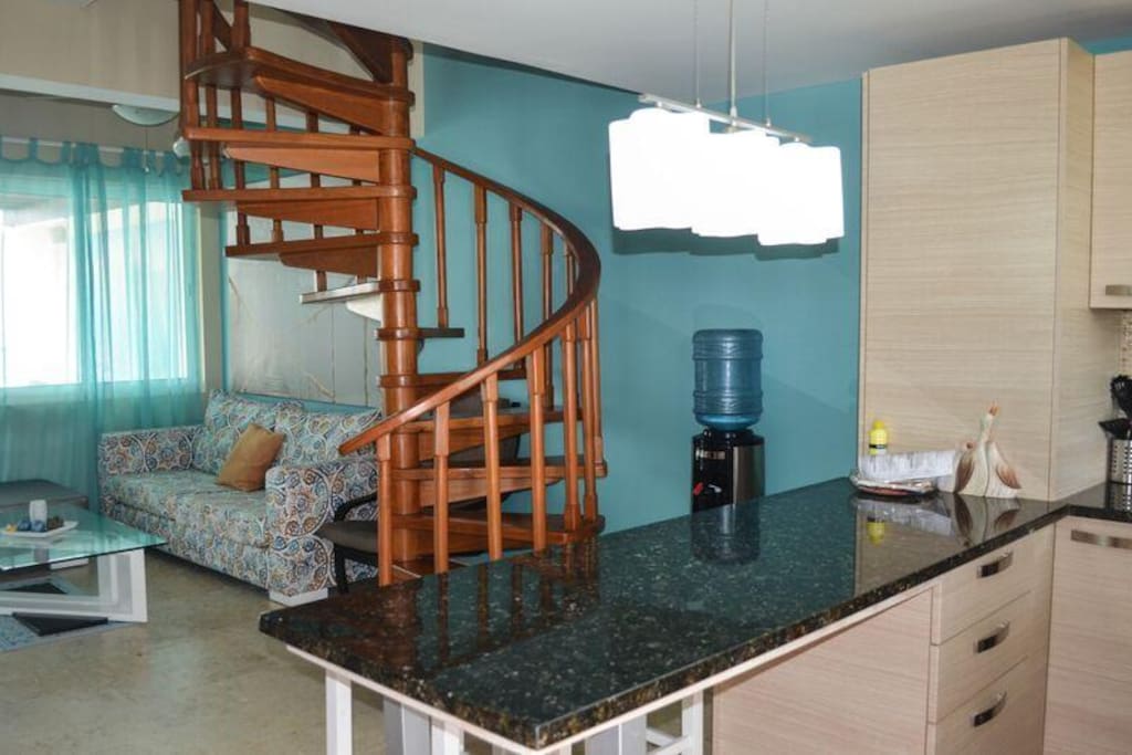 View from kitchen with living quarter and spiral staircase to loft