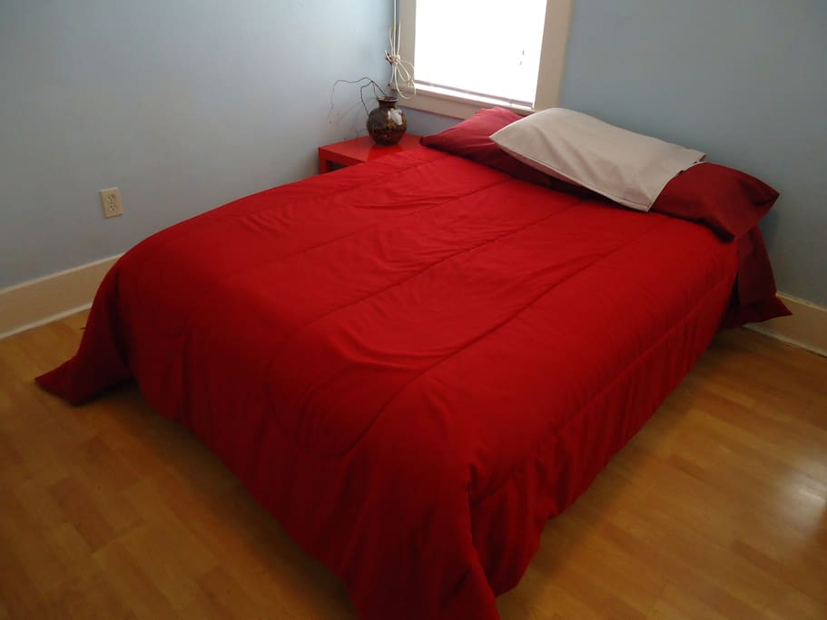 Comfy double bed with a little bedside table.