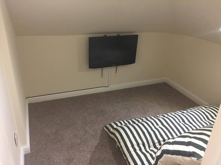 Sitting area with TV in room beside single room
