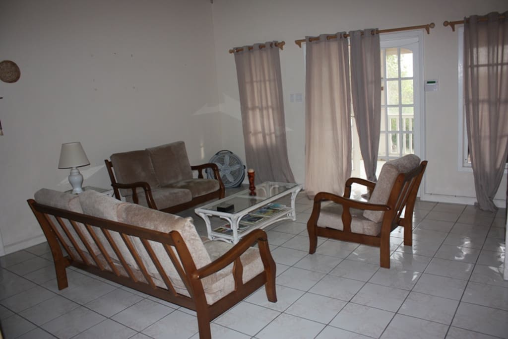 Genuine hardwood furniture set in a living area with large bay windows offer great lighting as well as sea and mountain views.