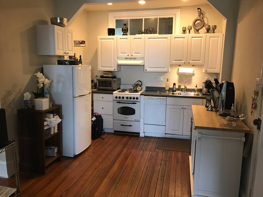 Kitchen with dishwasher, fridge freezer, wine rack, stove, microwave and utensils. Washer/dryer adjacent to kitchen.