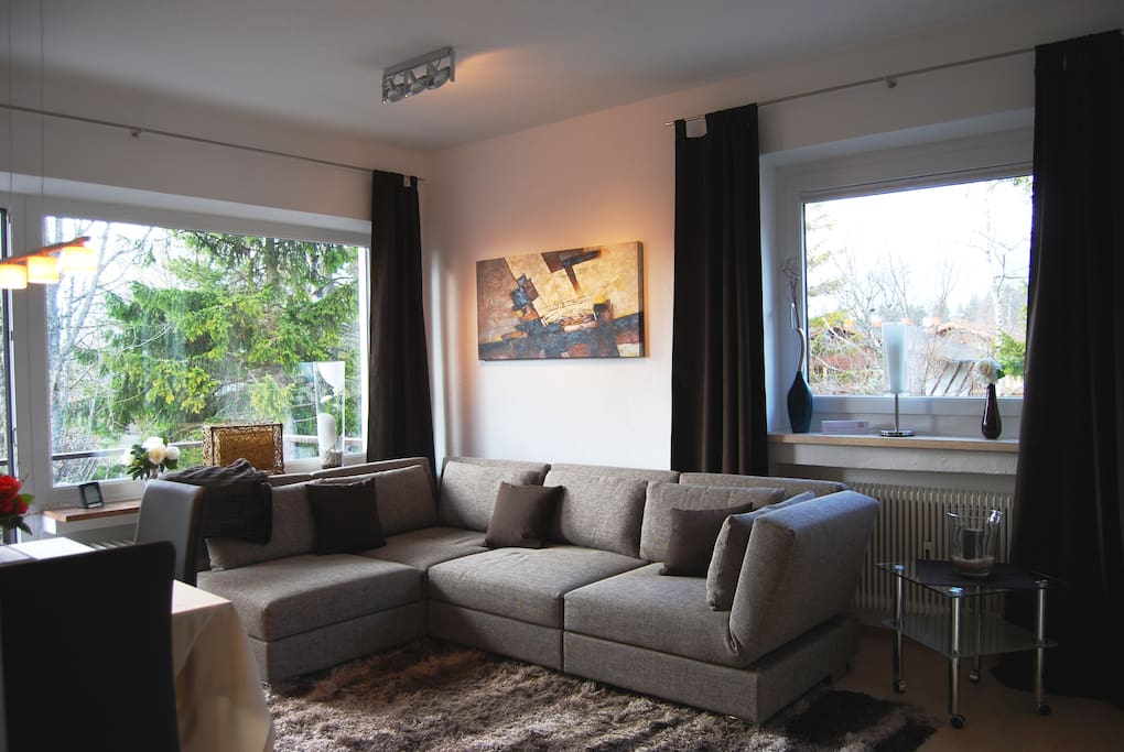 Wohnzimmer mit Deisgnersofa in dem ein zusätzliches Doppelbett 1,80 breit integriert ist.