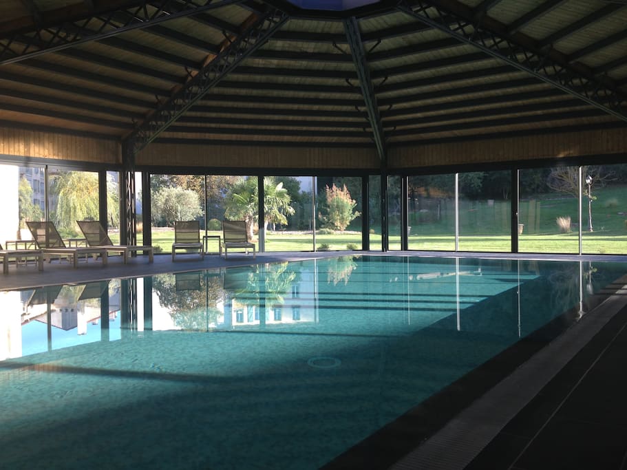 Piscine couverte chauffée à débordement avec vue sur le Parc