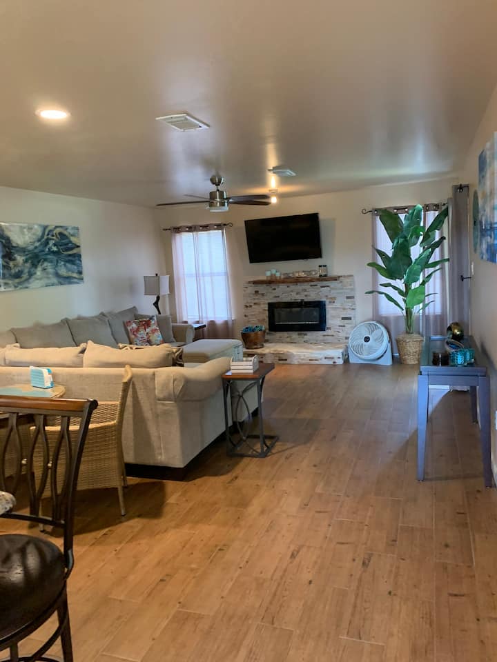 View of living room, with a 55 inch TV, large comfortable sectional sofa sleeper. 