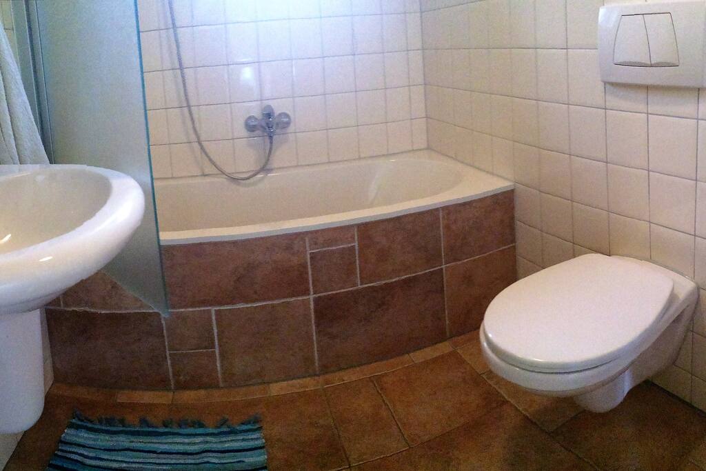 Badkamer met douche en ligbad