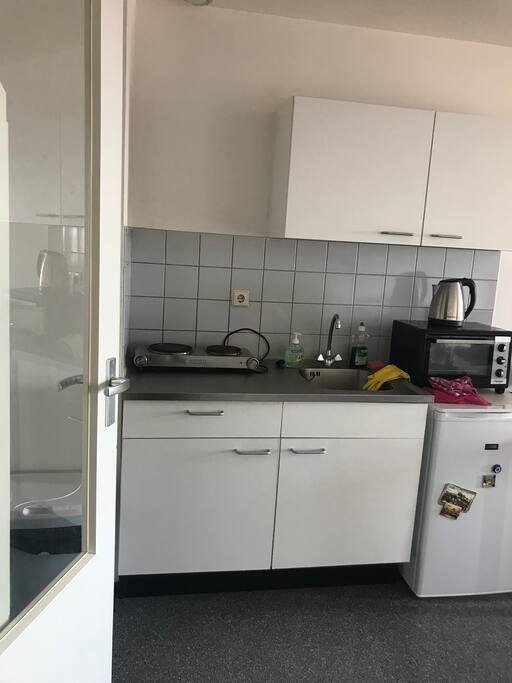 Kitchen with electric plate, fridge, small oven and a water cooker