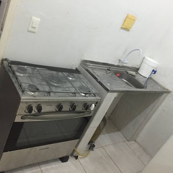 Cozinha americana com fogao, geladeira, microondas.