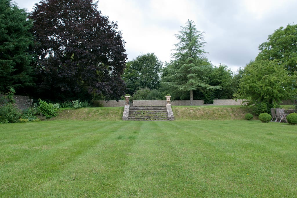 View of the formal lawn up to the vegetable and flower garden