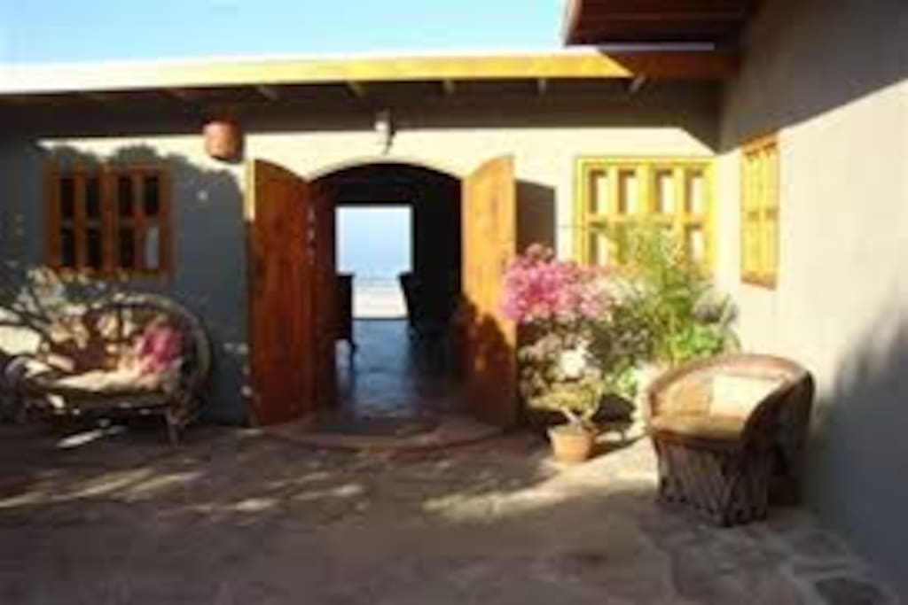 From the courtyard you can see the ocean through the french doors and the sliding glass door to the beach front terrace.