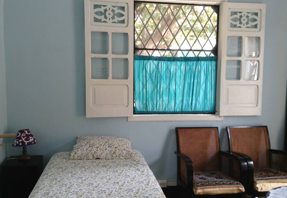 Single bed with extra pull out bed under. A set of two vintage chairs with round table and mirror available inside the room.