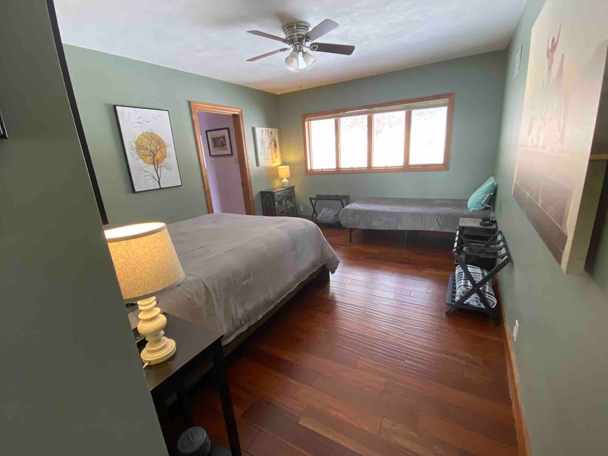 Main level bedroom with queen and twin bed.   The former closet has a baby crib shown in next pic.   Far door goes to full bathroom 