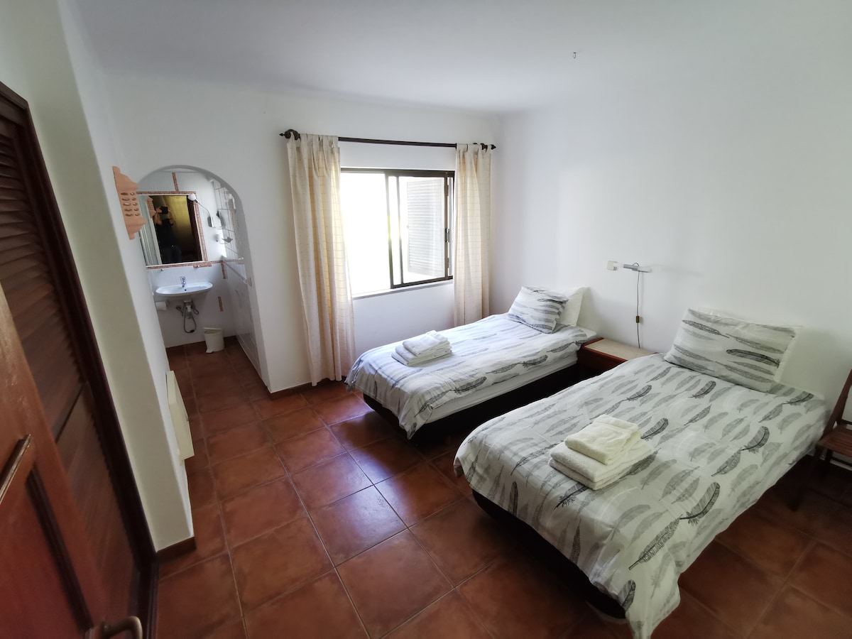 De andere slaapkamer met ook 2 eenpersoonsbedden heeft een badkamer ensuite.