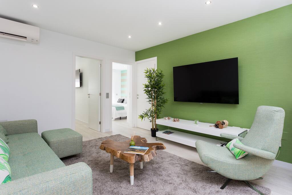 The lounge is air conditioned and includes a comfortable sofa (which can be converted into a single bed), a 65'' TV with access to Netflix and a large dining table. El salón tiene aire acondicionado y un cómodo sofá -que se puede convertir en una cama individual-, una televisión de 65'' con acceso a Netflix y una gran mesa de comedor.