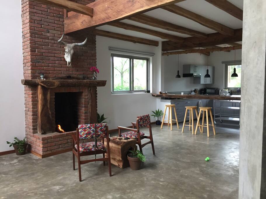 Left View kitchen and fireplace with guest room with two beds and independent bathroom with sink toilet and shower.