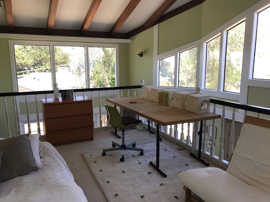 Loft has a large work station, a corner desk, and a small dresser.