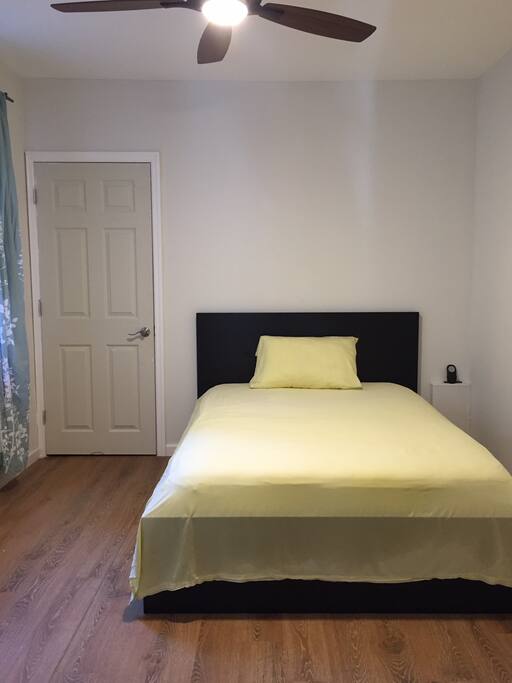 Bedroom with a door through a storage room into the backyard