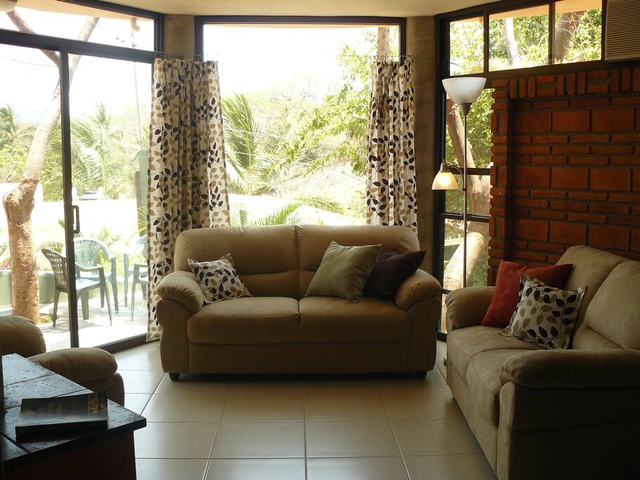 Living room with its wall of windows to the patio