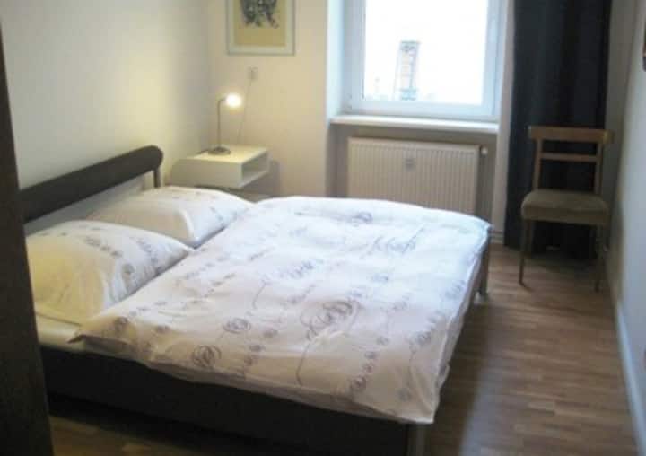 السرير المزدوج (1.80 × 2.00) في غرفة النوم الصغيرة. يحصل كل ضيف على بطانيته الخاصة (وليس فقط بطانية مشتركة كما في الصورة)