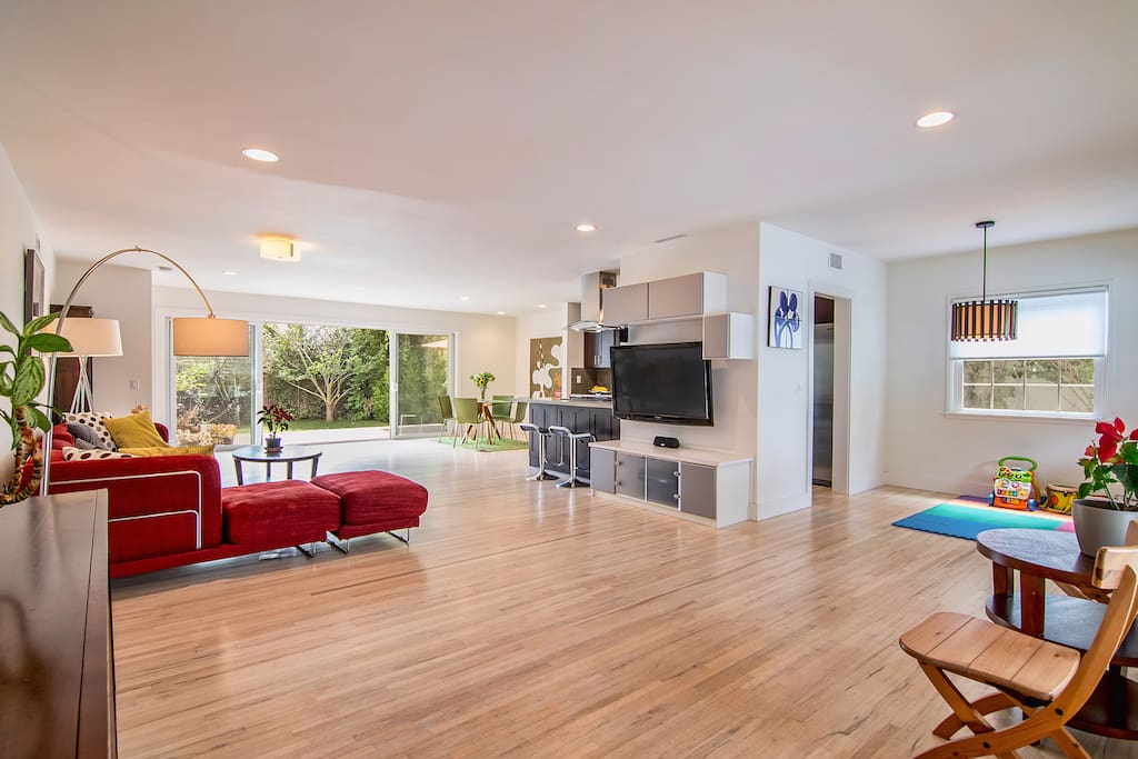 Open living room with couch, dining table, TV and kitchen