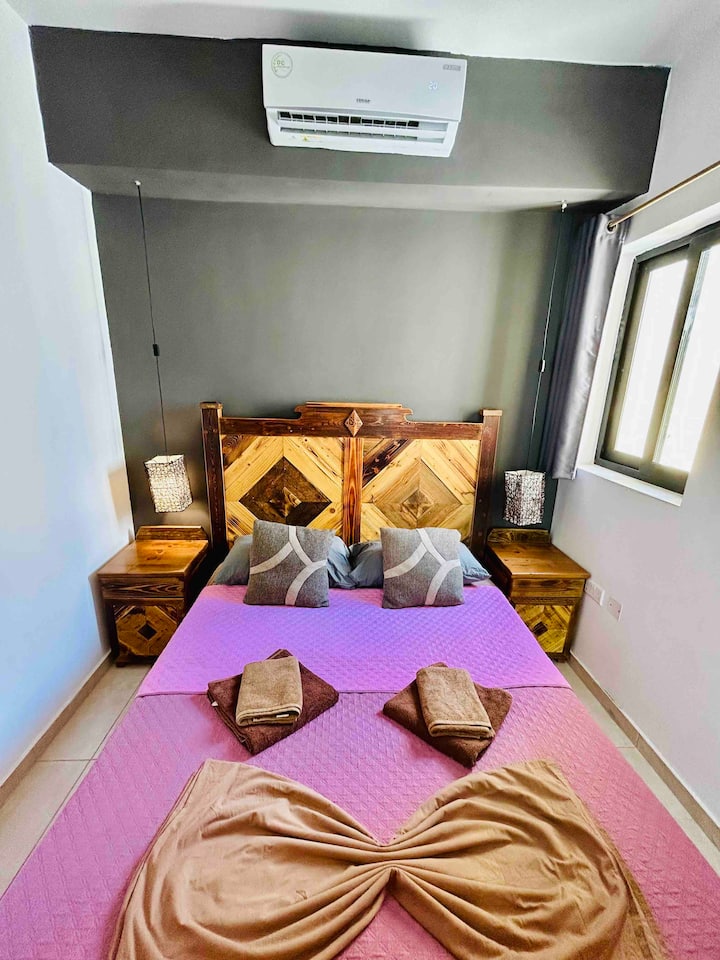 ห้องนอนที่ 1 สถานที่แห่งความสะดวกสบายไม่มีที่สิ้นสุด มีหัวเตียงโต๊ะข้างและประตูแบบสั่งทำพิเศษ