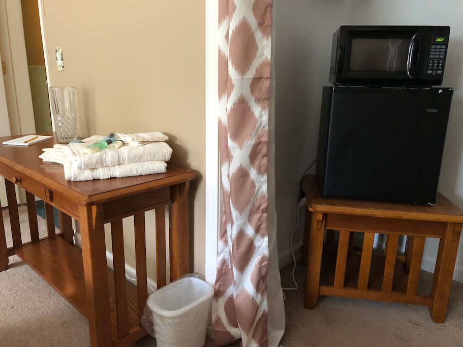 Microwave and fridge area and a personal items table in the Tan King room