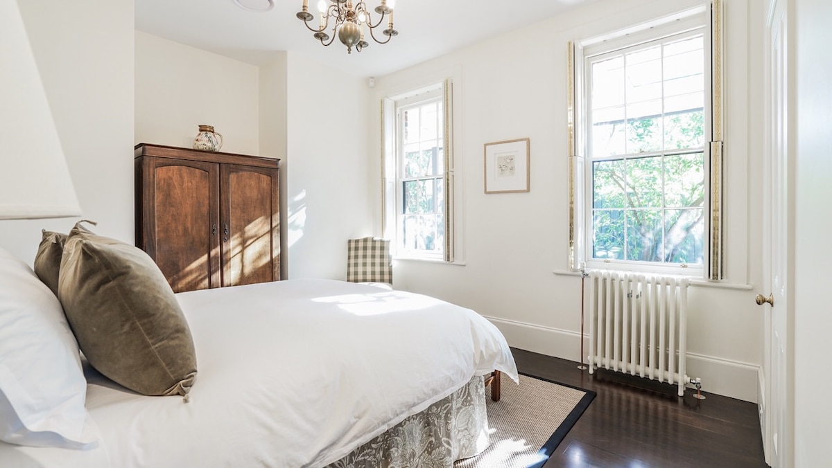 El dormitorio de David Unaipon está inundado de sol de la tarde. Las ventanas ofrecen una vista sobre el jardín de fernery recién instalado.