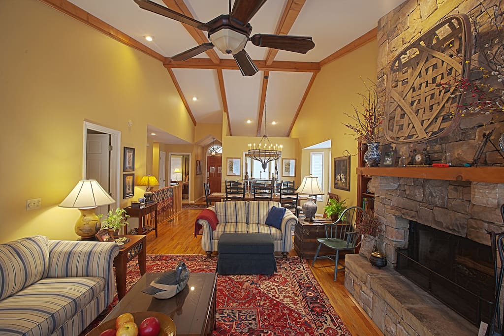 The great room of this Windsor town home offers hardwood floors, high vaulted ceilings with boxed beams, stone fireplace, and sliding glass doors that lead to an open deck. #fireplace