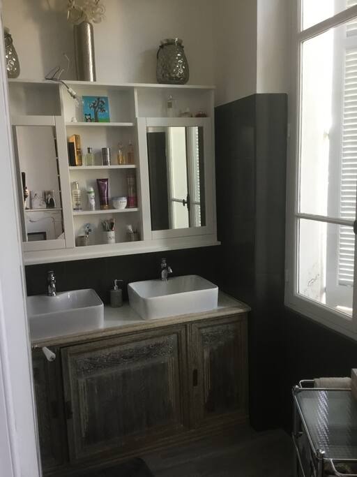 Salle de douche de la suite parentale avec toilettes, grande douche et double vasque.