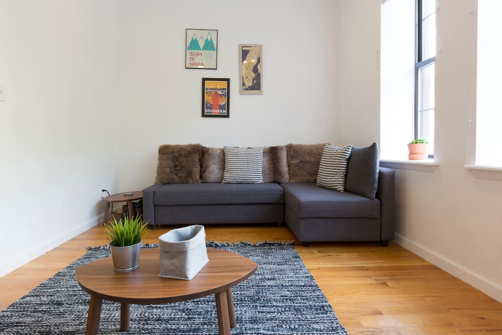 Living room with comfy cushions, thematic wall art, and bright natural light