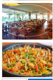 A spacious dining area is filled with wooden tables and chairs, designed to accommodate guests comfortably. Large windows allow natural light to illuminate the space, creating a bright and airy atmosphere. Greenery is visible outside, enhancing the inviting setting.