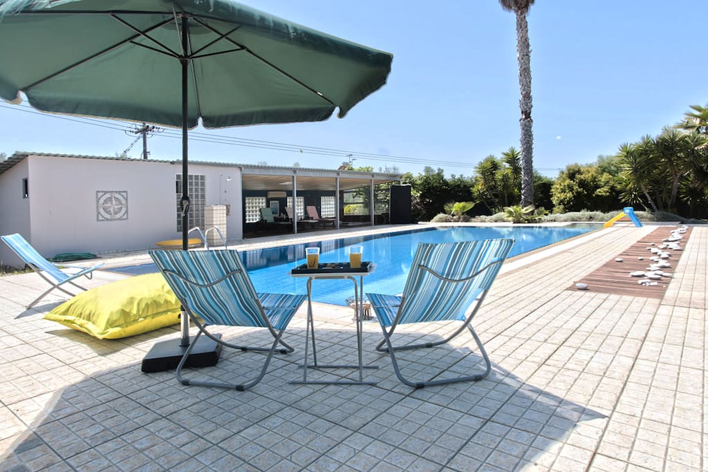 Outdoor swimming pool, relaxing area with chairs for sunbathing and view towards Taygetos mountain