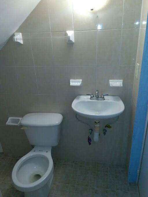 baño completo con lavabo, inodoro y regadera.