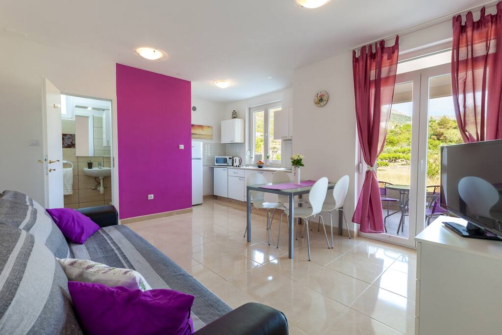Living room & kitchen, with exit to covered balcony (10sqm)