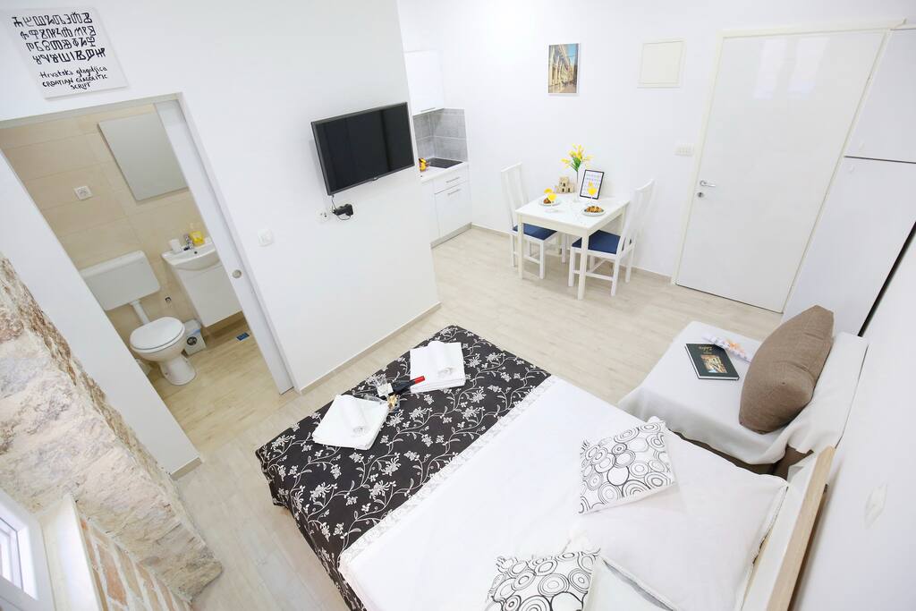 Bed, sofa, table for two, bathroom