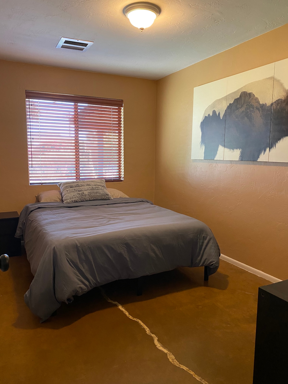 Chambre #1 - Complet avec un lit queen, grand miroir de sol au plafond, et commode.