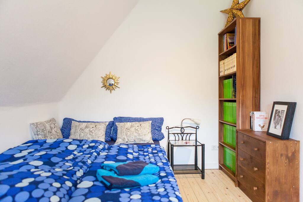 Dein Bett neben der kleinen Gästebibliothek