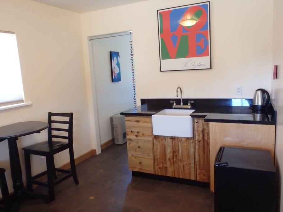Kitchenette with custom cabinets, granite counter, and dining table for 2