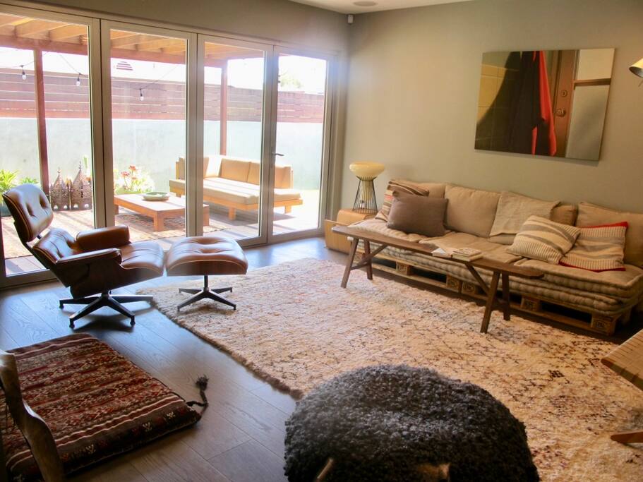 Living Room with a wall of glass doors that open to the backyard garden