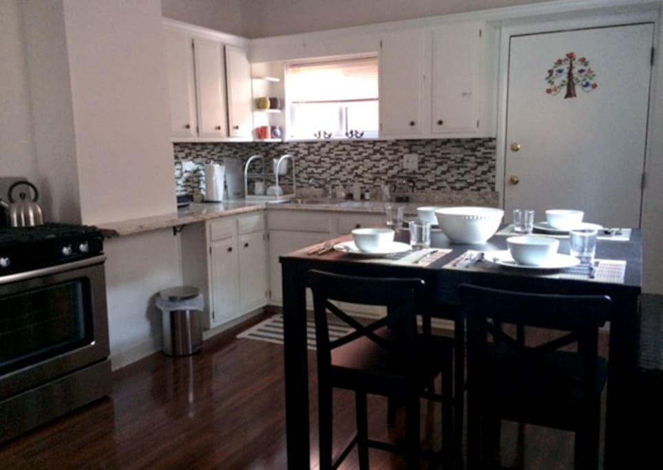 Kitchen with new oven, microwave, fridge and seating for four.