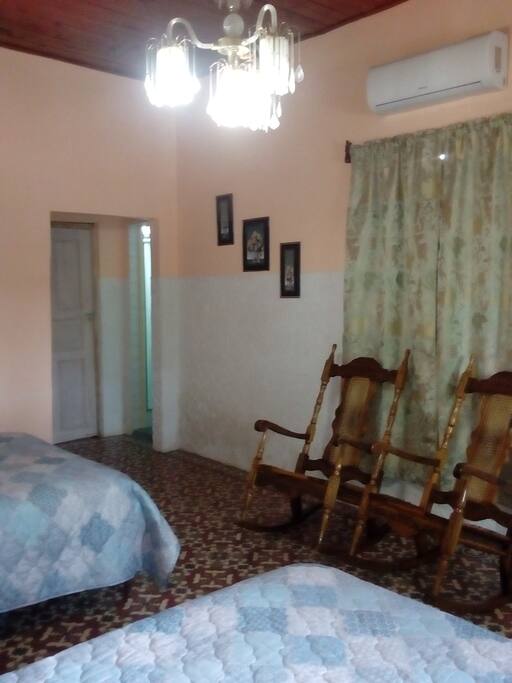 Foto de la habitacion donde se muestra el split, cillones y la entrada del baño privado.