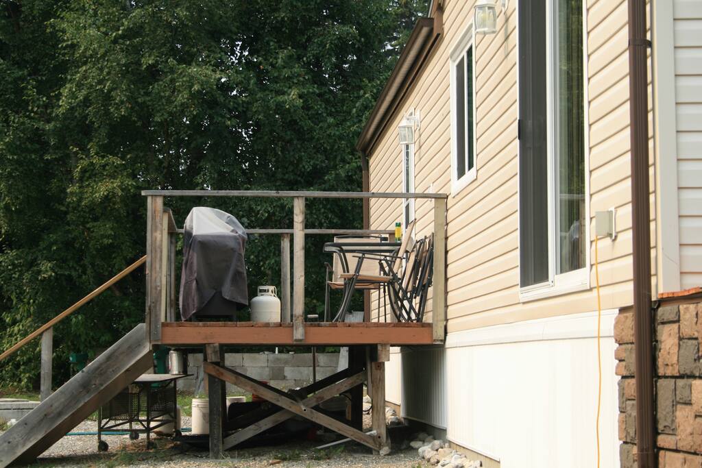small deck off main enterance with BBQ and outside dinning area