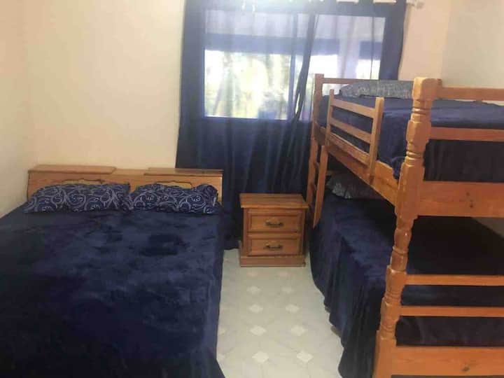 Chumba kikubwa cha kulala chenye kitanda kimoja cha watu wawili na vitanda viwili vya ghorofa vilivyo na kabati na Kiyoyozi
