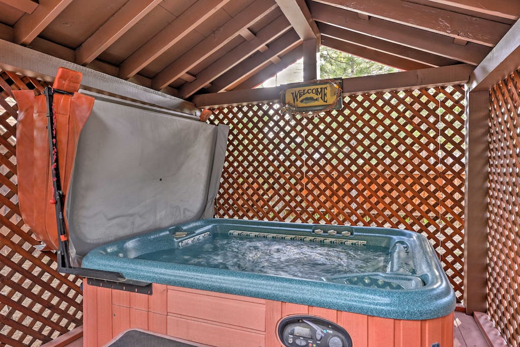 This cozy cabin has a fenced-in backyard with a patio and hot tub.