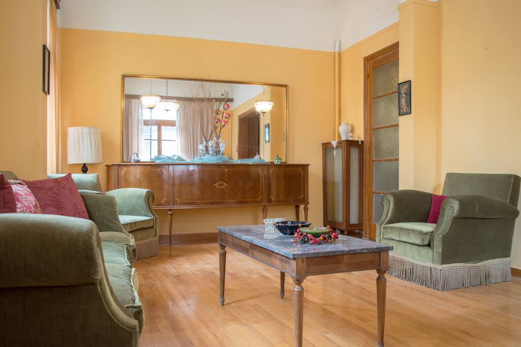 Cozy and elegant vintage living room to relax and unwind after a long day. The living room is equipped with a comfortable sofa and armchairs and has great lighting conditions all day.