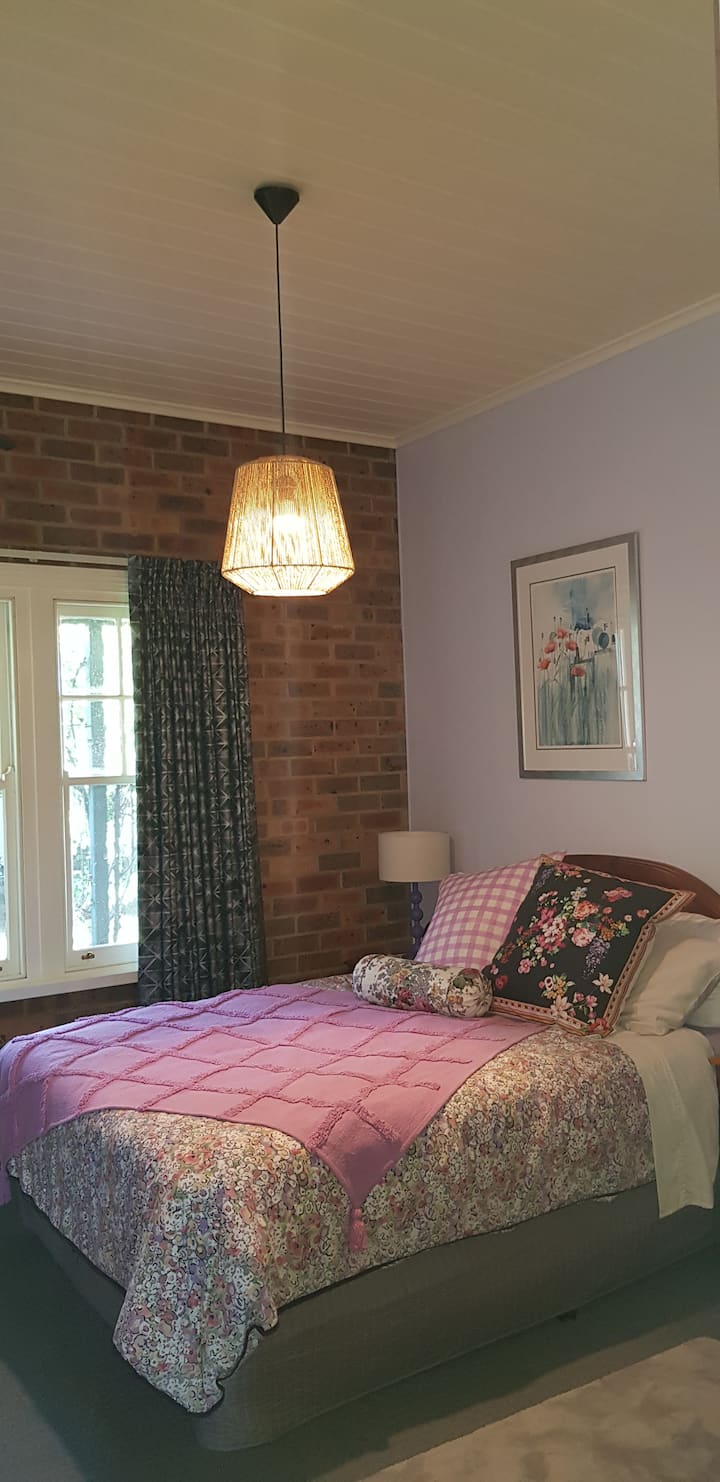 Dormitorio uno con cama tamaño queen. Ubicado junto al baño de invitados y al otro lado del pasillo del salón, donde puedes relajarte y planificar tus días. Te  serviremos brekky en el salón. 