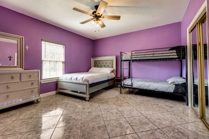 La chambre violette dispose d'un lit Queen Size et d'un ensemble de lits superposés. 