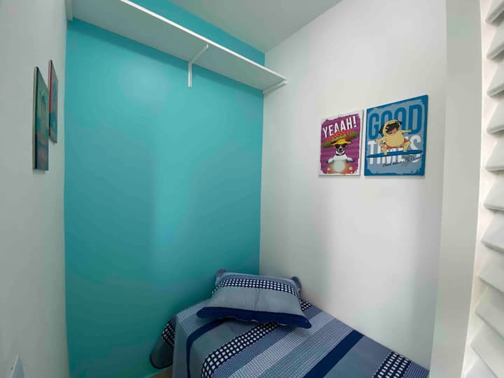 Kleine kamer met eenpersoonsbed en plafondventilator 